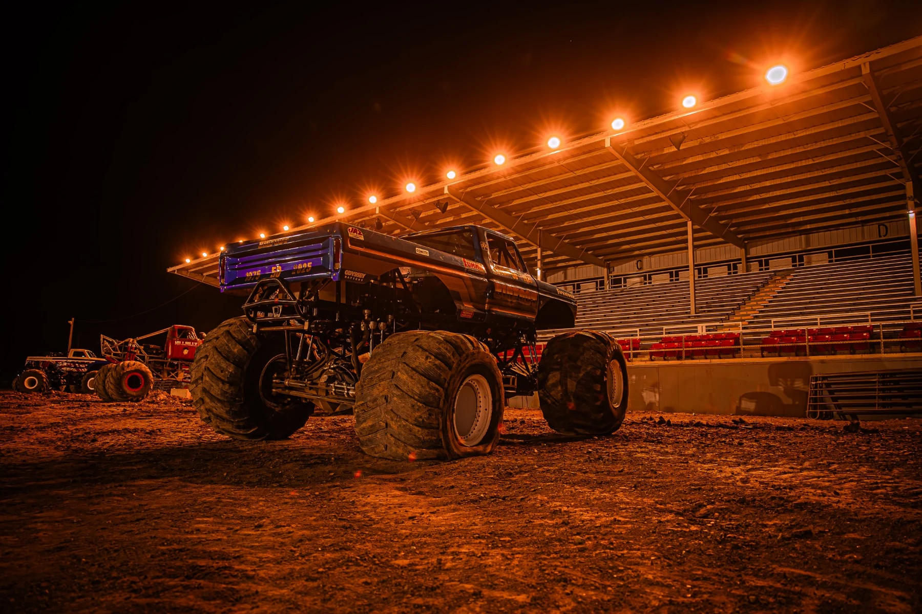 Monster truck under stadium lights at night