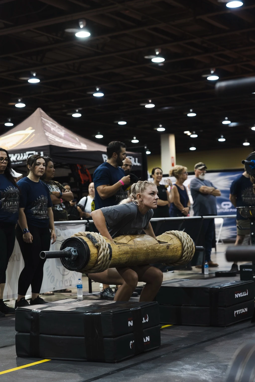 Strongwoman athlete lifting a log during competition
